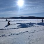 pêche sur glace sur un lac gelé en Laponie